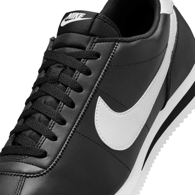 Men's black Nike Cortez close-up, lace-up design with white swoosh