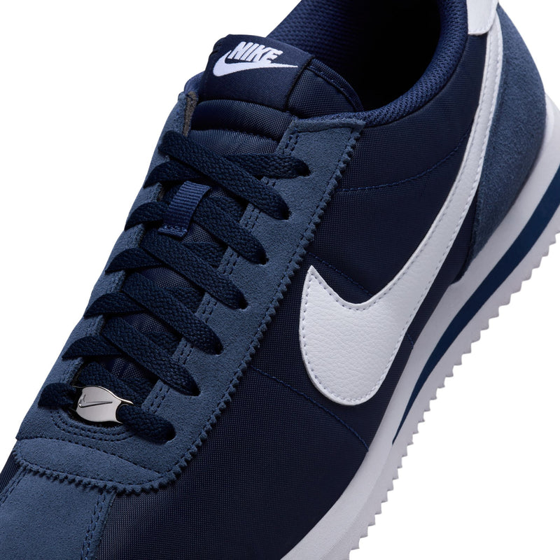 Men's Cortez sneaker close-up: navy laces, white swoosh, and side panel