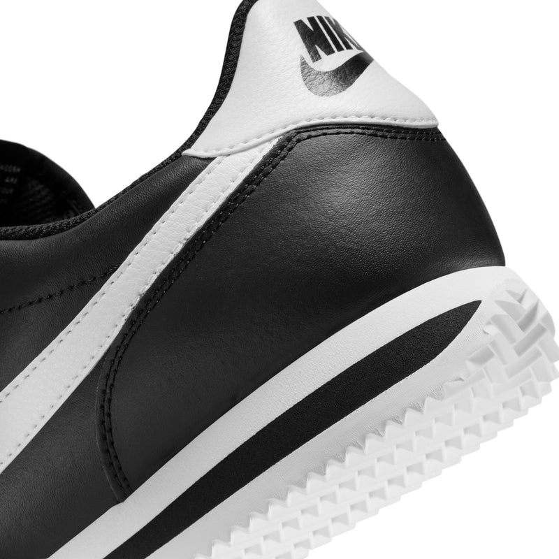 Men's black Nike Cortez close-up, white midsole stripe and textured outsole