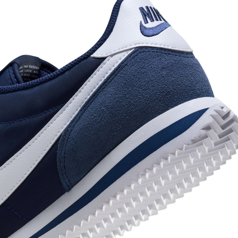 Men's Cortez sneaker close-up of side and outsole; navy suede and white stripes