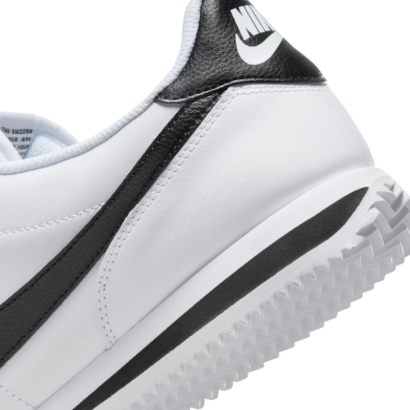White and black men's low-top sneaker side view with Nike swoosh and textured sole