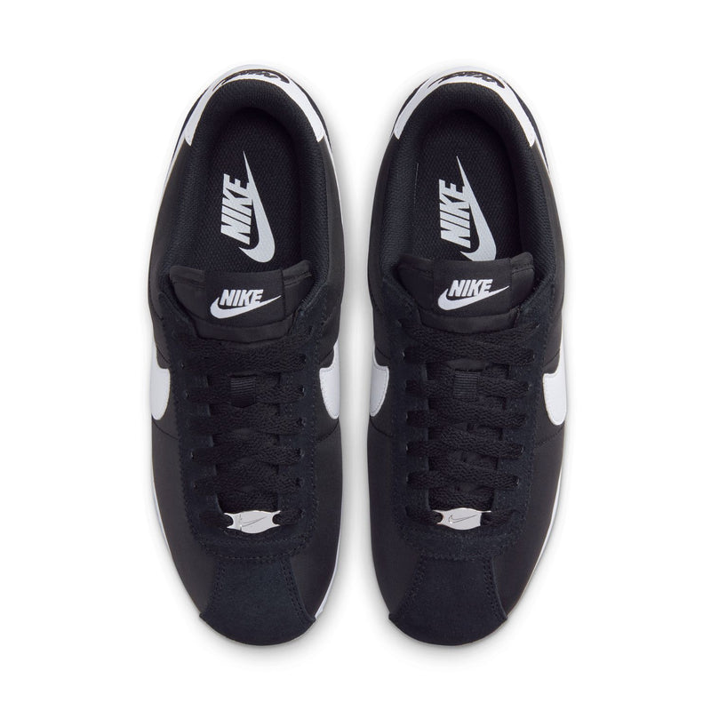Black lace-up sneakers with white Swoosh and Nike logo on tongue