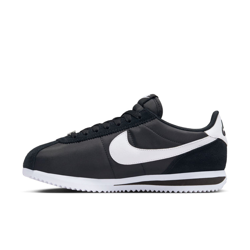 Black low-top sneakers with white Swoosh and white midsole stripe