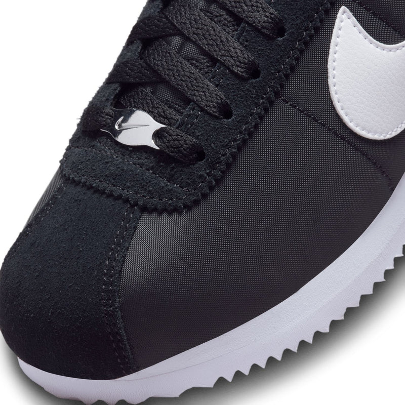 Close-up of black sneaker with lace-up top and white Swoosh