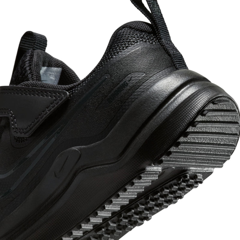 Close-up of kids black running shoe tread, sidewall, and cushioned midsole