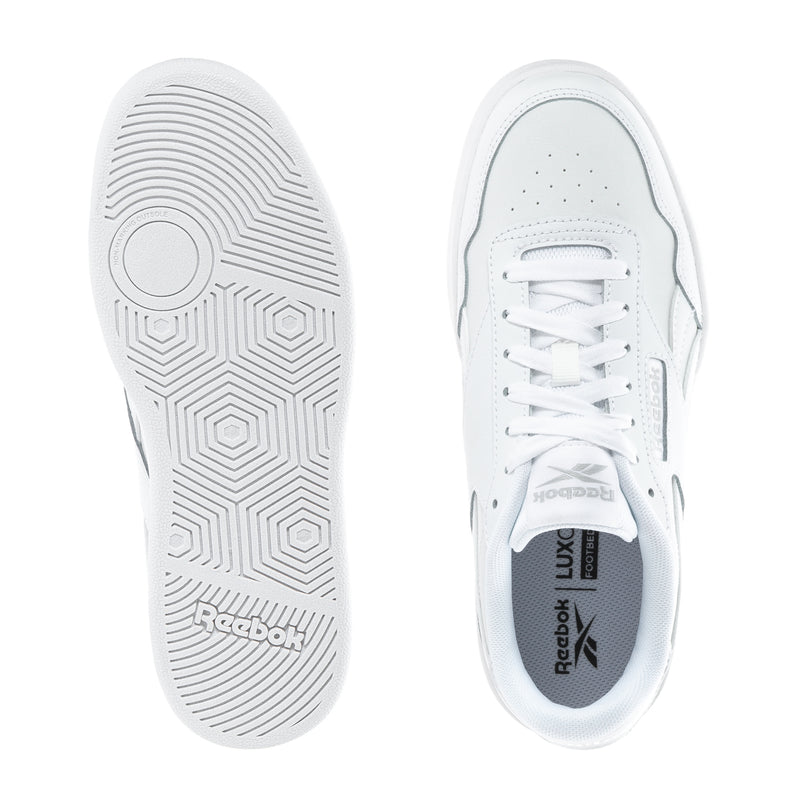 Women's white sneakers showing outsole tread and Reebok logo on inner tongue