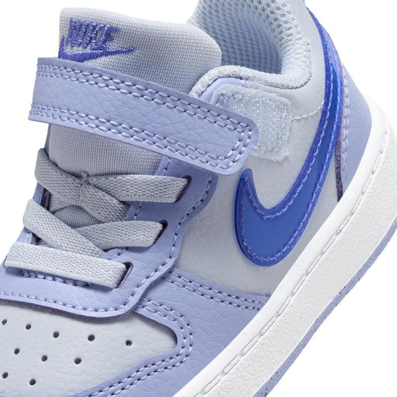 Close-up of toddler sneaker upper with Nike swoosh, hook-and-loop strap, and stitching