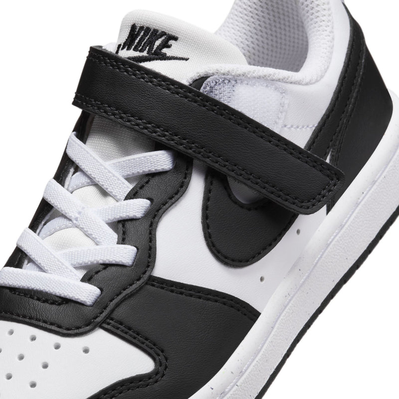Close-up of kids sneakers, white laces with black strap and black Nike swoosh