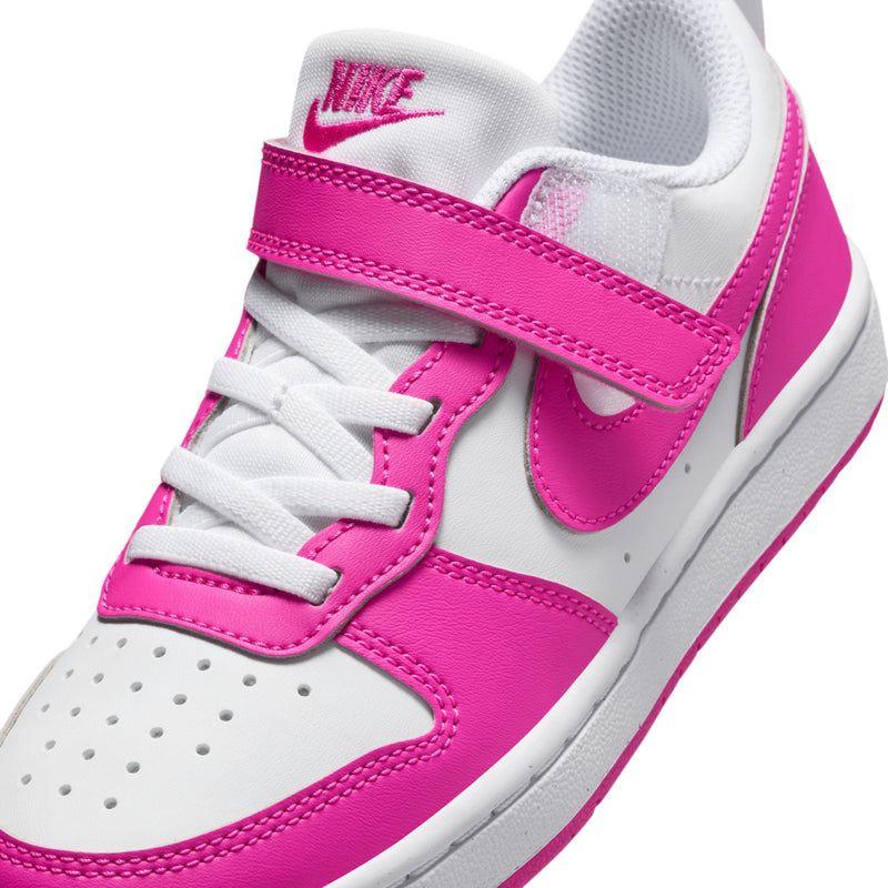 Kids sneaker close-up: white laces with fuchsia strap and swoosh, textured sole edge.