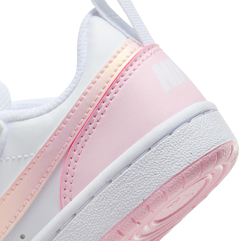 Kids sneaker side close-up in white and light pink with Nike logo and textured sole