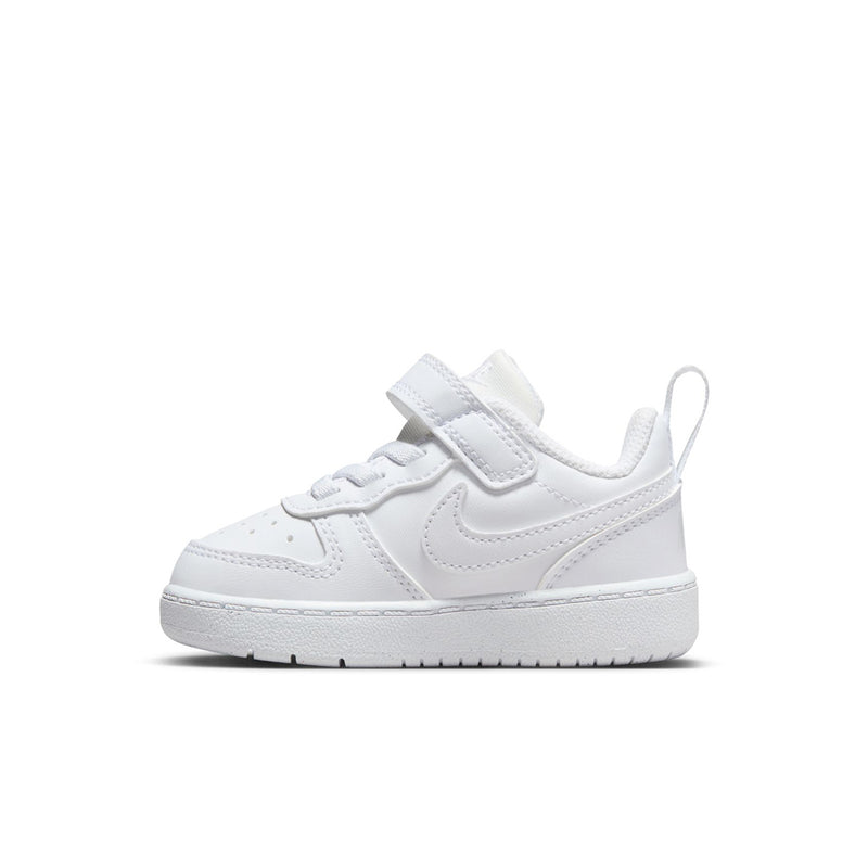 Toddler white low-top sneakers, angled side view with swoosh and strap