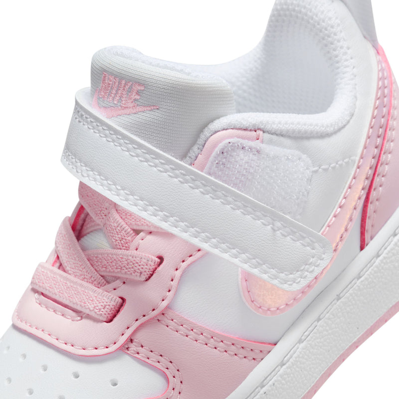 Toddler sneaker close-up: hook-and-loop strap, pink swoosh, and Nike branding on tongue.