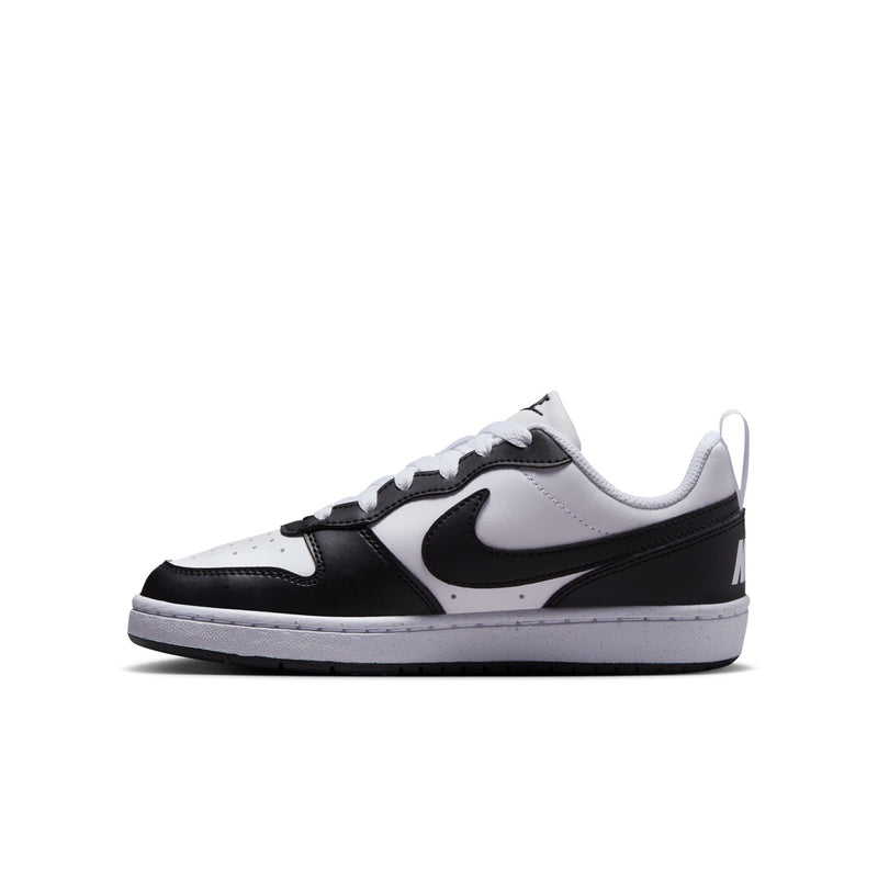 Youth low-top sneakers in white and black with visible swoosh and rubber cupsole
