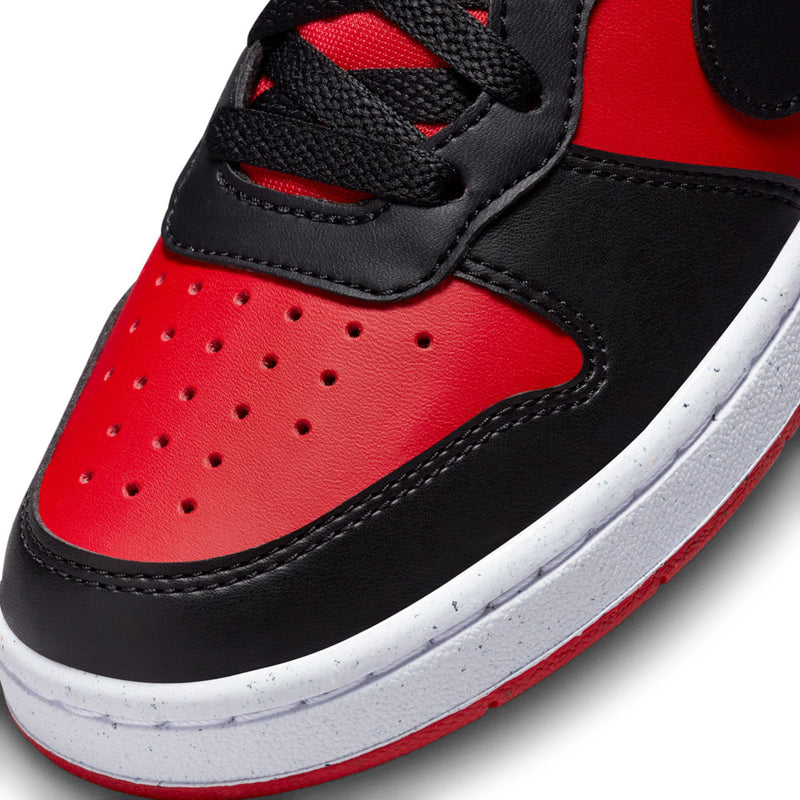 Youth sneaker close-up: red toe panel with perforations, black overlays, white midsole