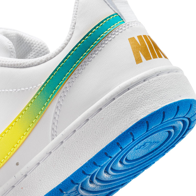 Close-up of youth sneaker side and sole edge with NIKE text and blue tread outsole