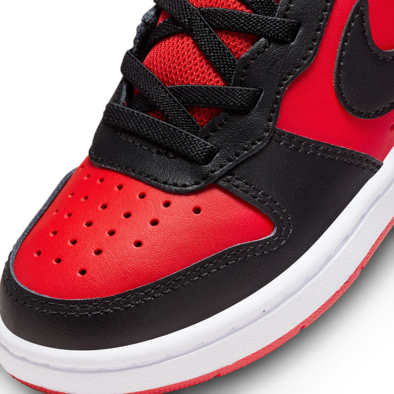 Kids mid-top shoe close-up, red leather toe with black laces and strap