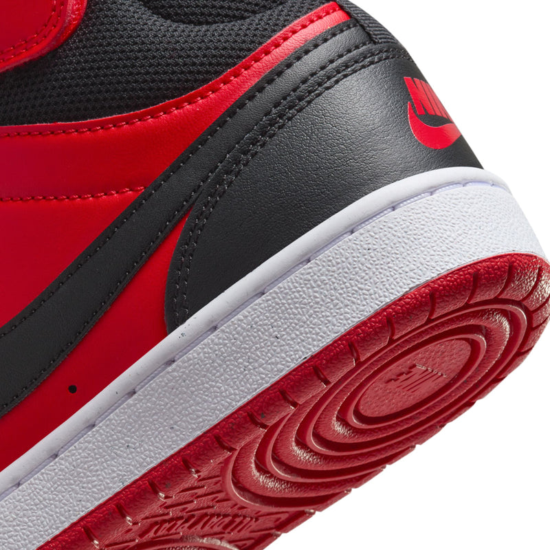 Close-up of youth Nike side panel, black strap with red Swoosh and white midsole