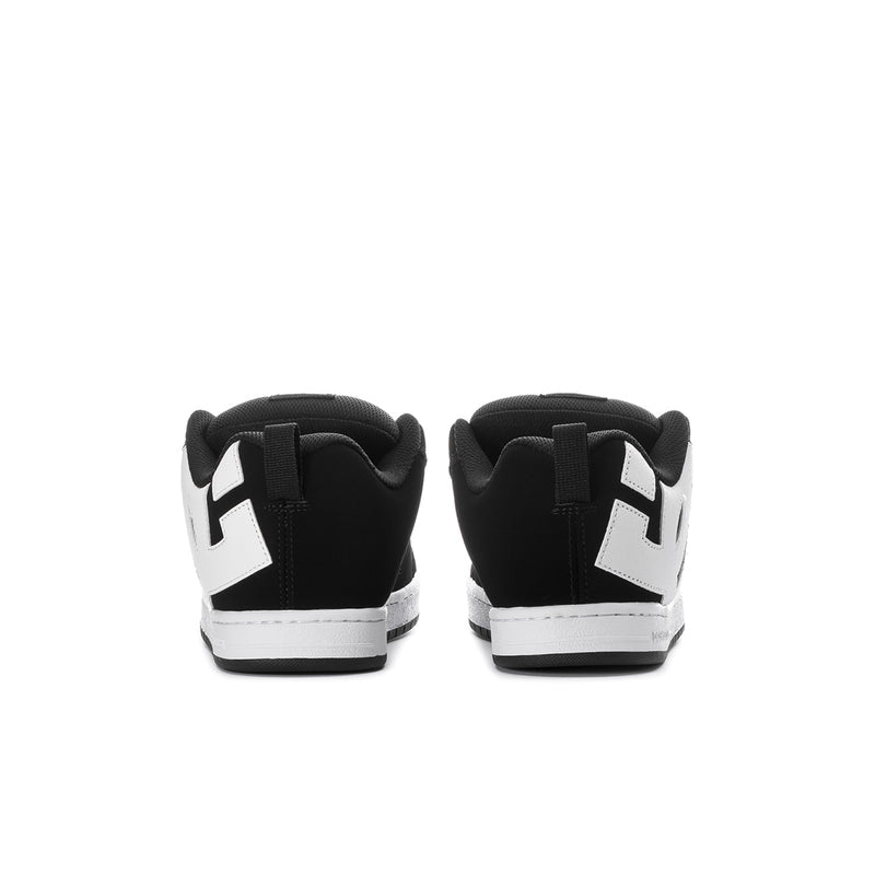 Black low-top sneakers with white heel panels and DC logo tabs at back.