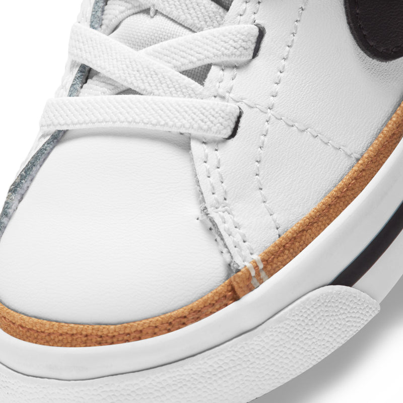 Toddler sneaker close-up, white leather upper with tan edge and textured sole
