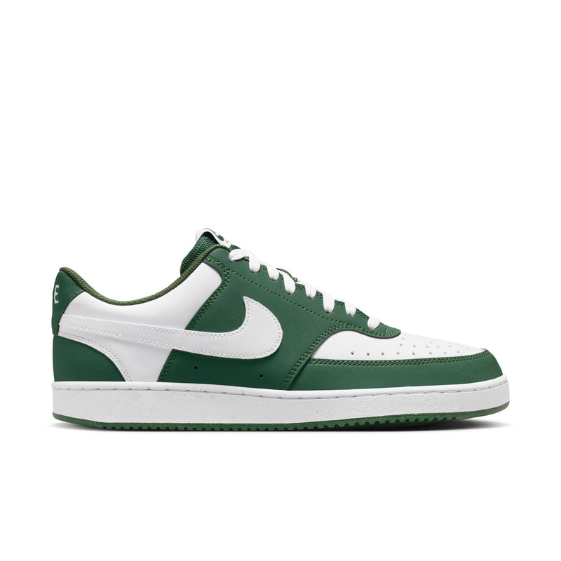 Green and white low-top lace-up sneakers with large white swoosh and perforated toe