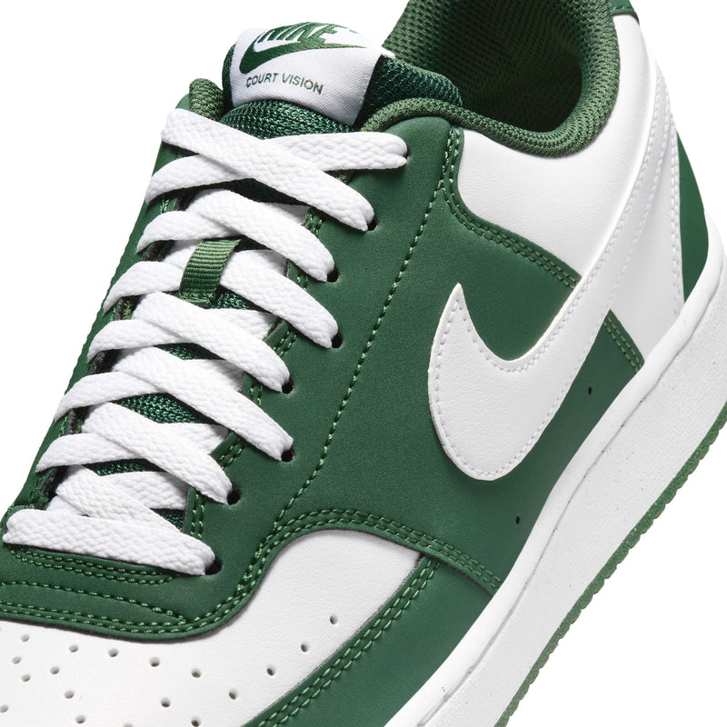 Close-up of green and white low-top sneakers with white laces and COURT VISION tongue