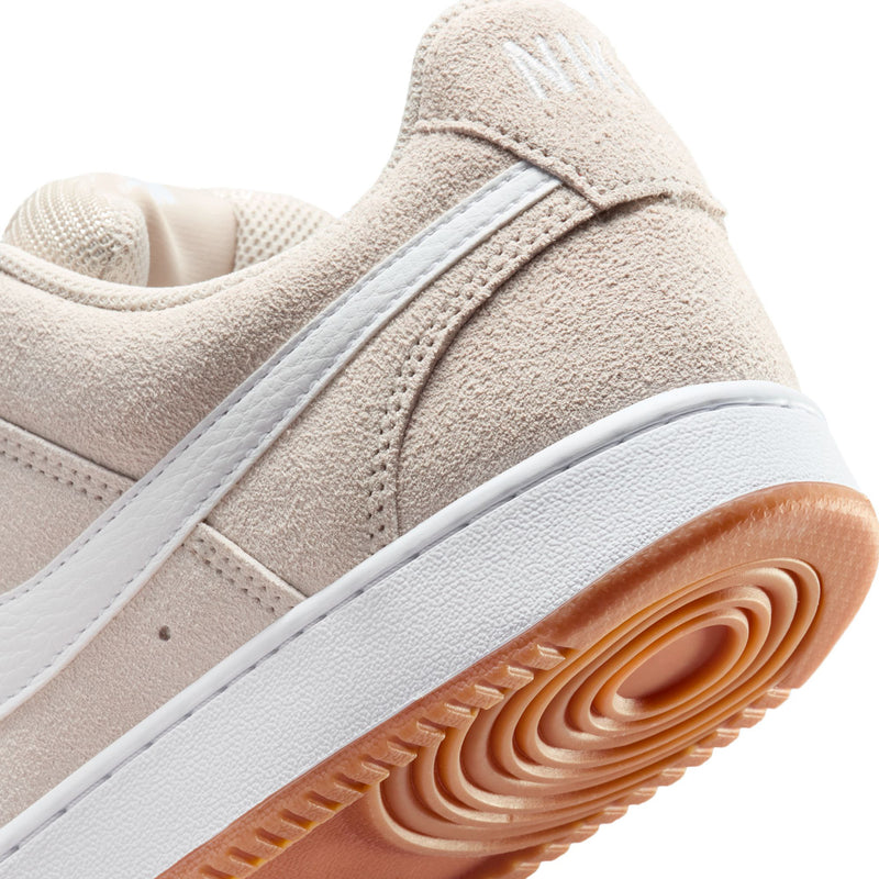 Close-up of light brown suede sneaker with white stripe, white midsole, gum tread