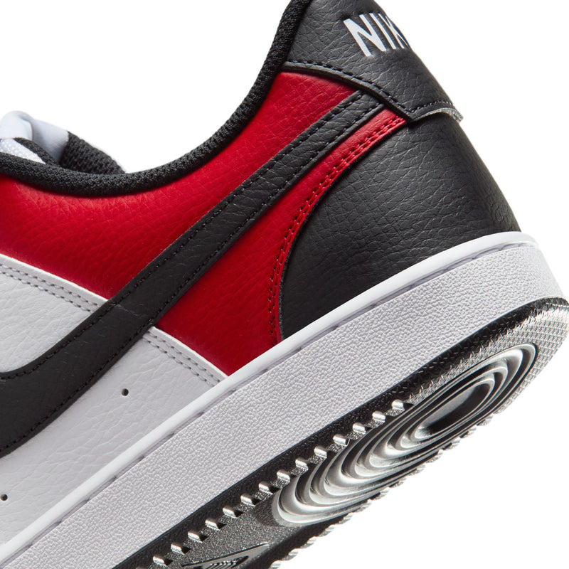 Close-up of white and red leather sneaker with black trim and textured outsole edge.