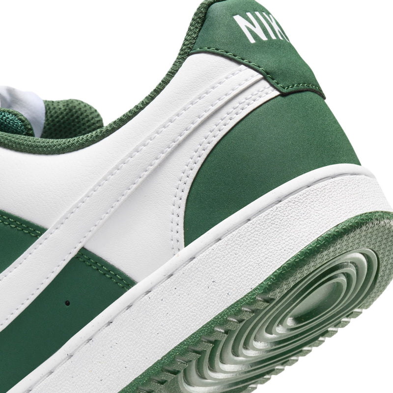 Side close-up of green and white low-top sneakers with white swoosh and textured midsole