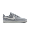 Light gray low-top sneakers with white swoosh and lace-up closure
