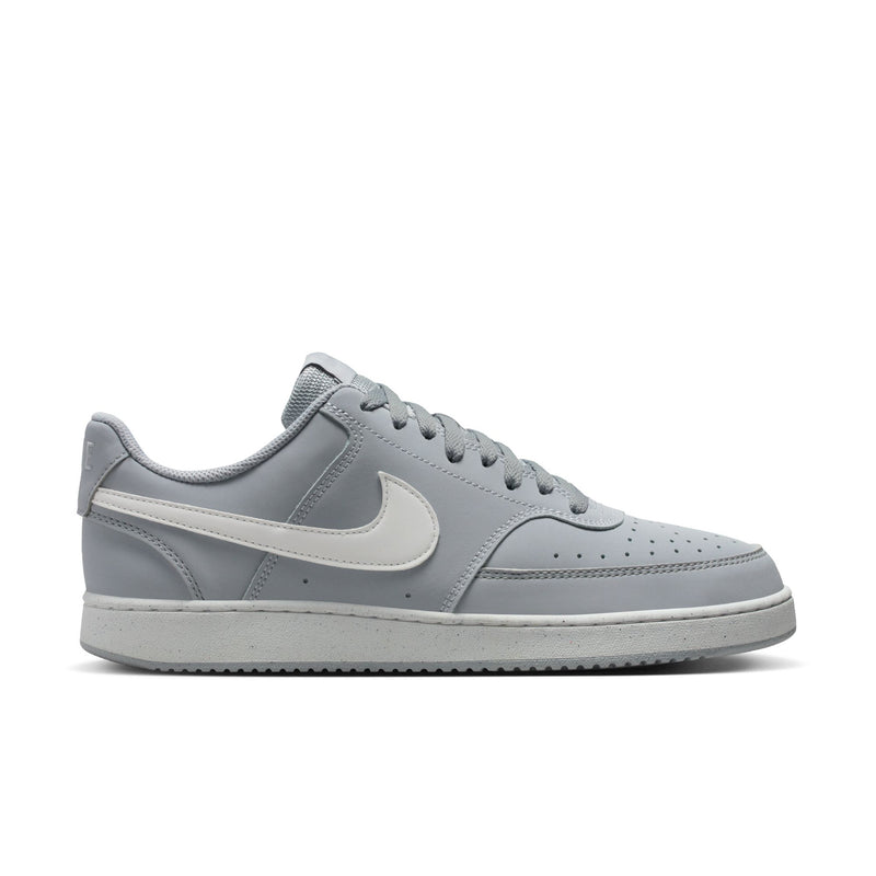 Light gray low-top sneakers with white swoosh and lace-up closure