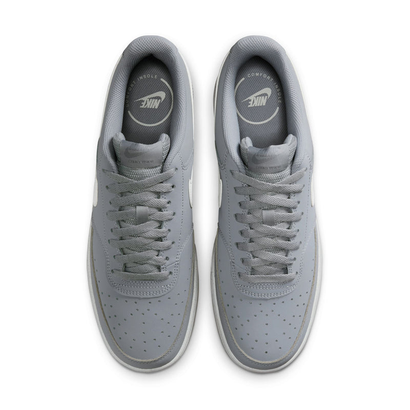 Light gray sneakers with perforated toe and Nike logo on tongue
