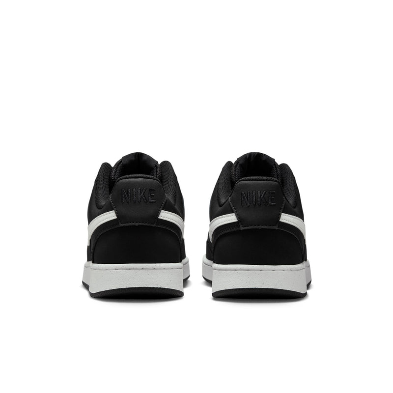 Black low-top sneakers with white heel tab and midsole, rear view