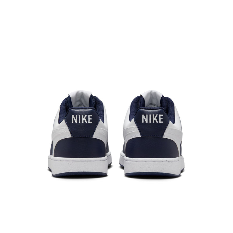 Men's low-top sneakers heel view in navy and white with Nike label and rubber sole.