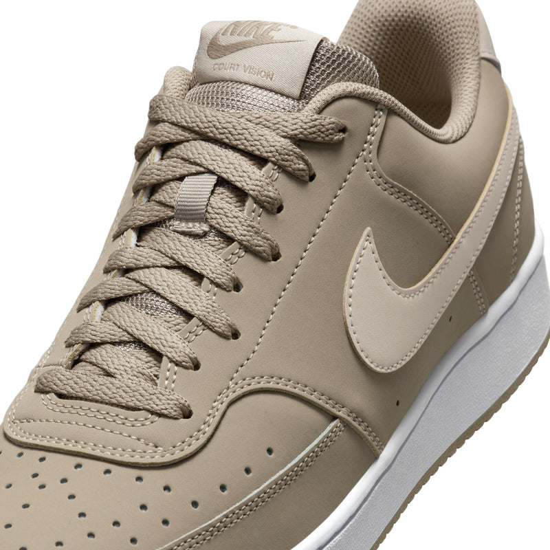 Men's low-top sneakers close-up, tan laces and panels with white swoosh