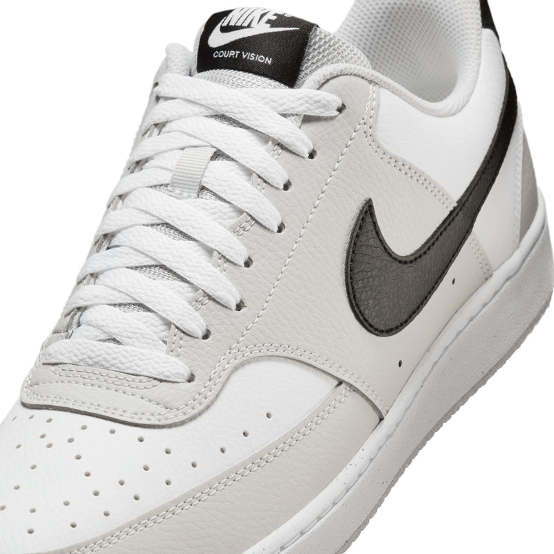 Close-up of low-top men's sneaker upper in white with black swoosh and perforations.