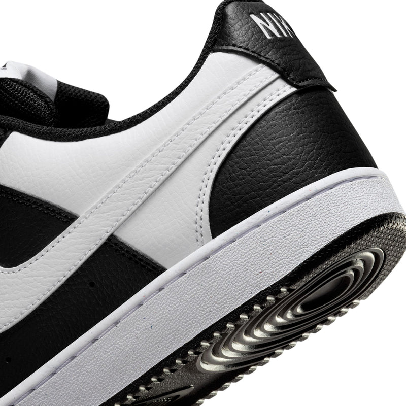 Men's low-top sneakers, black and white, leather texture and side stripe detail.