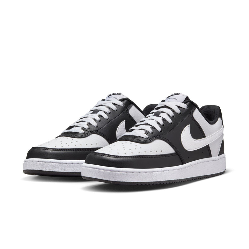 Women's low-top sneakers, side view; black leather-look with white swoosh and laces