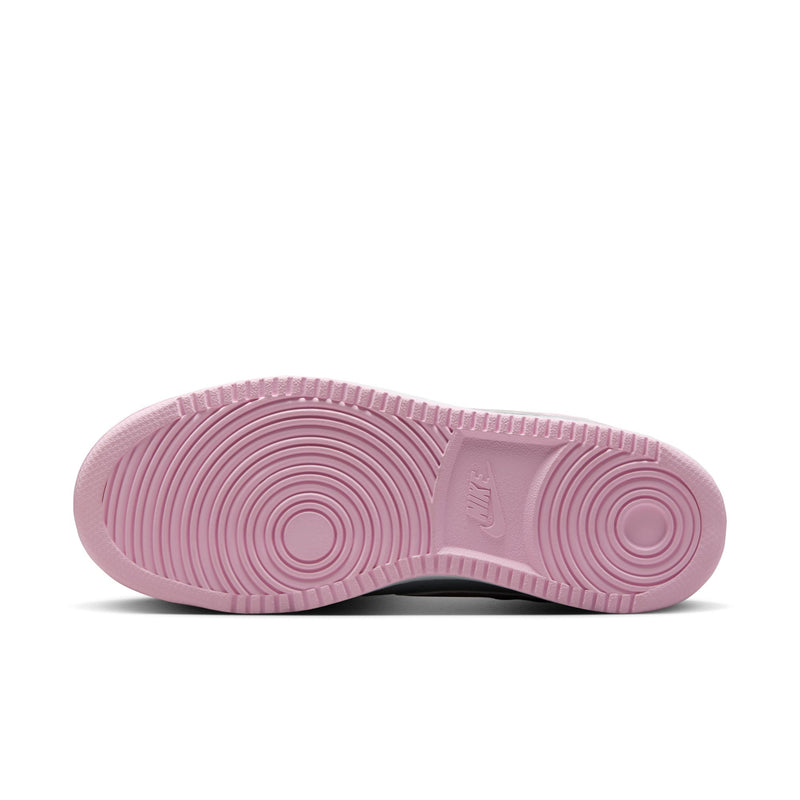 Outsole of women’s low-top sneakers, pink rubber traction with circular tread pattern.