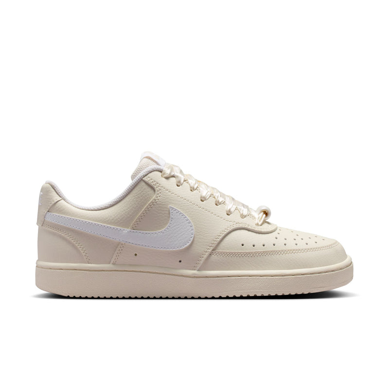 Women’s low-top cream Nike sneakers, lace-up style with light blue Swoosh