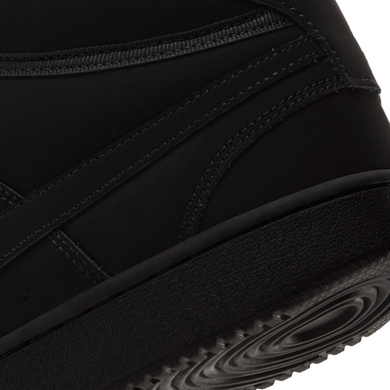Men's black mid-top sneaker side panel with stitched seams and textured sole edge