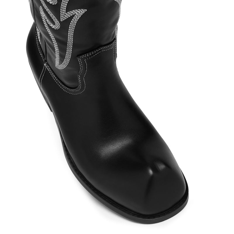Black cowboy boot with white stitching on a white background