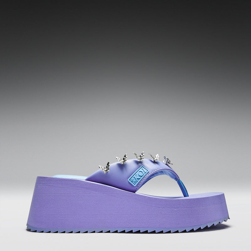 Purple sandal with decorative elements on a gray background