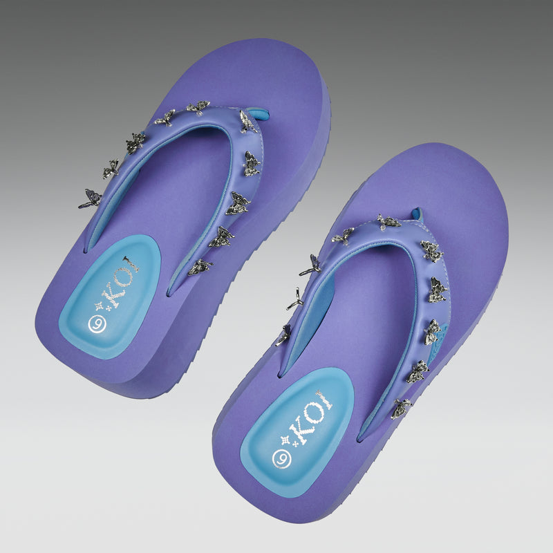 Purple flip-flops with decorative elements on a gray background