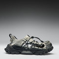 Black and gray sandal with unique sole design on a gradient background