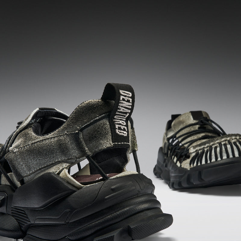 Pair of black and brown sneakers with textured design on a gray background