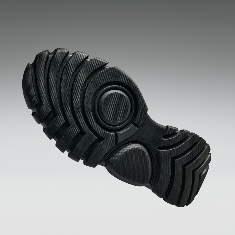 Black rubber sole with tread pattern on a gray background