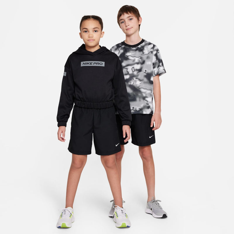 Youth black athletic shorts with elastic waist and Nike swoosh, worn in outfit