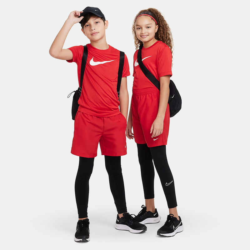 Youth red shorts paired with black leggings and sneakers; elastic waistband and swoosh