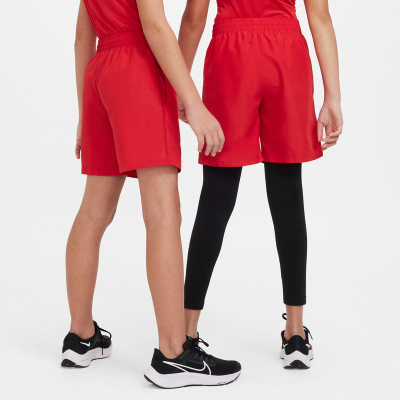 Red youth shorts with elastic waist; worn over black leggings with sneakers