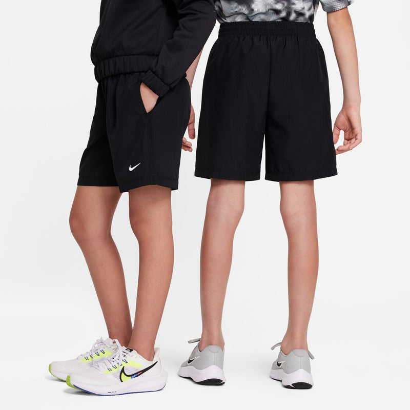 Black youth woven athletic shorts with elastic waistband, worn with sneakers